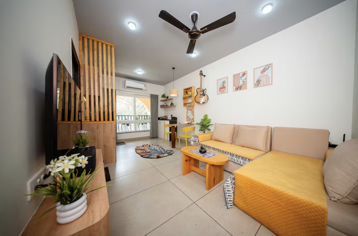 Boho living space with mustard sofa and balcony light — Goa