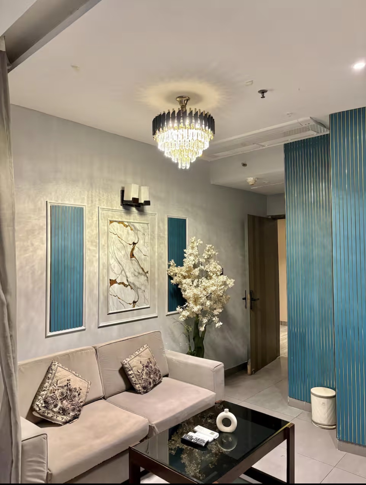 Elegant living lounge with crystal chandelier and marble art