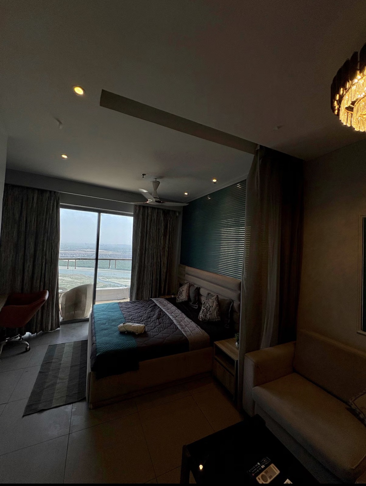 Master bedroom opening onto a high-floor balcony with skyline view