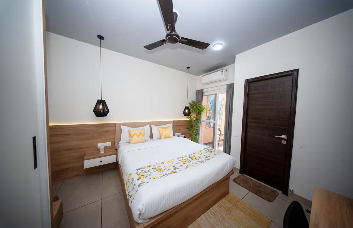 Bright bedroom with pendant lights and floral bed runner