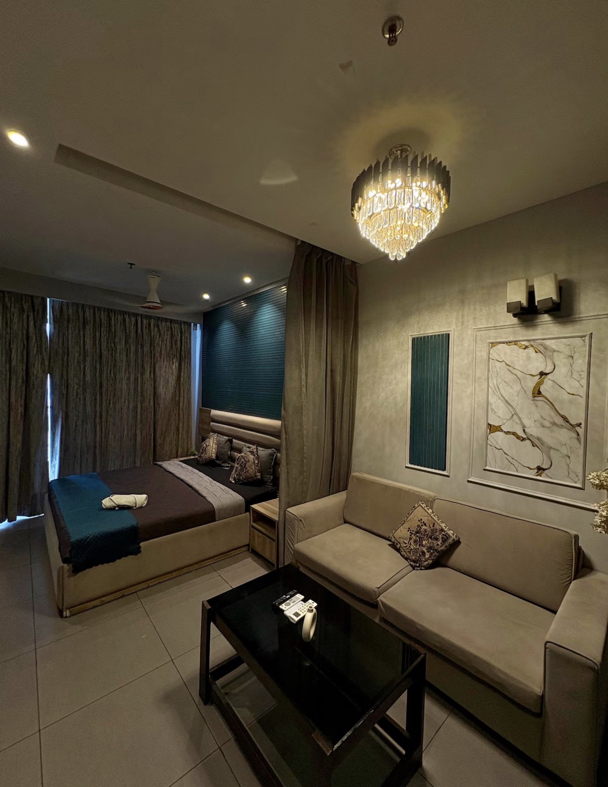 Studio suite with bed, sofa lounge and statement chandelier — Noida
