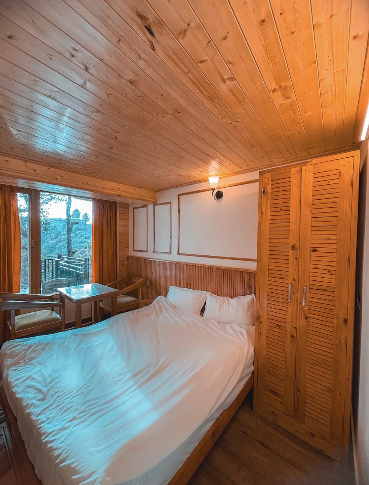 Cozy wood-panelled bedroom opening to a private balcony
